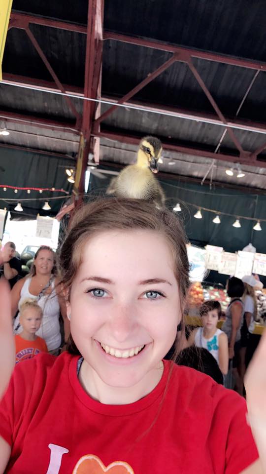 woman with a baby duck on top of her head